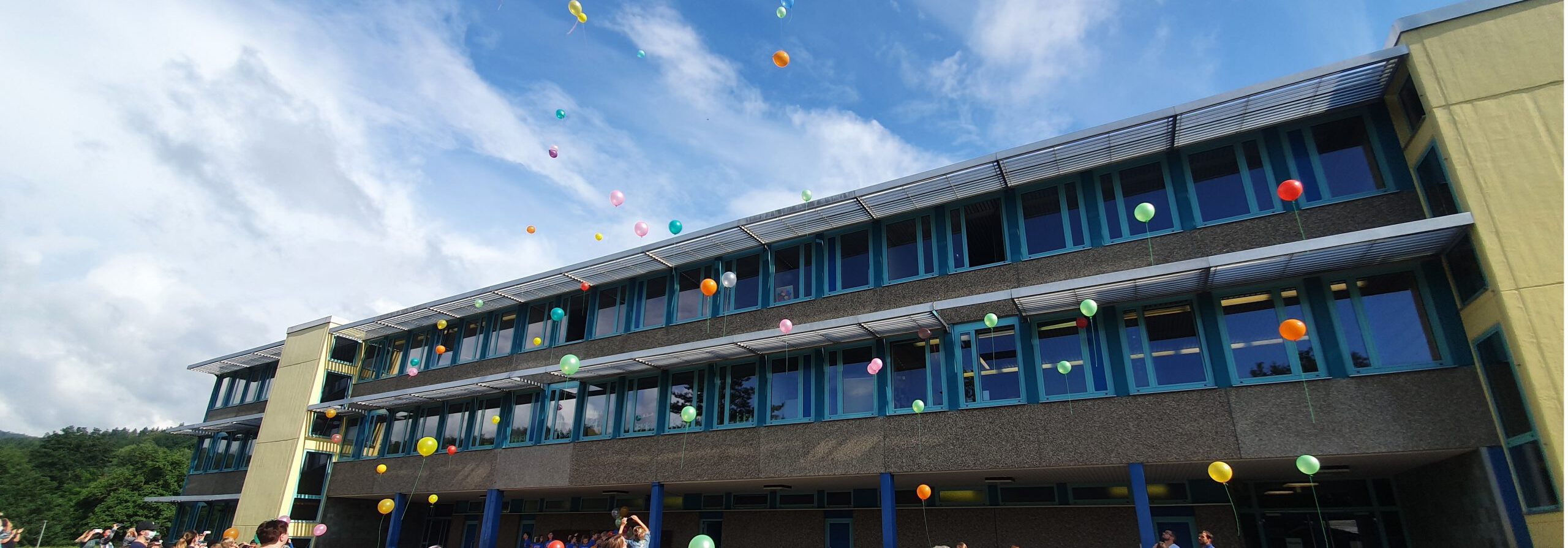 Gebäude der Felsland Grundschule mit aufsteigenden Luftballons